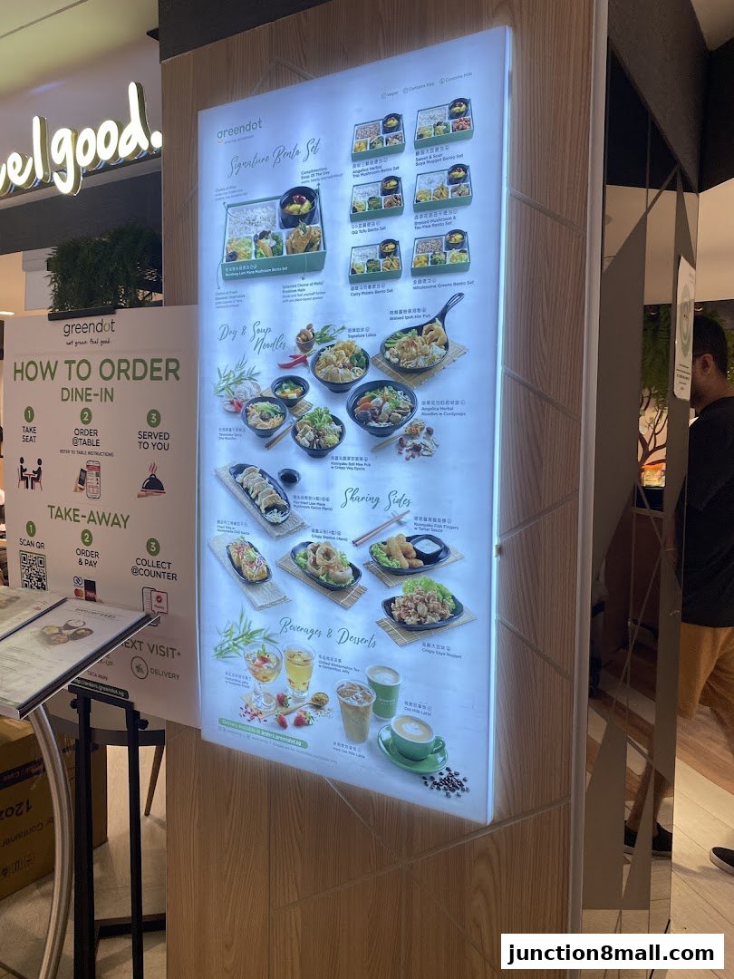 A brightly lit menu board showcasing Greendot's signature bento sets, noodles, sides, and beverages.