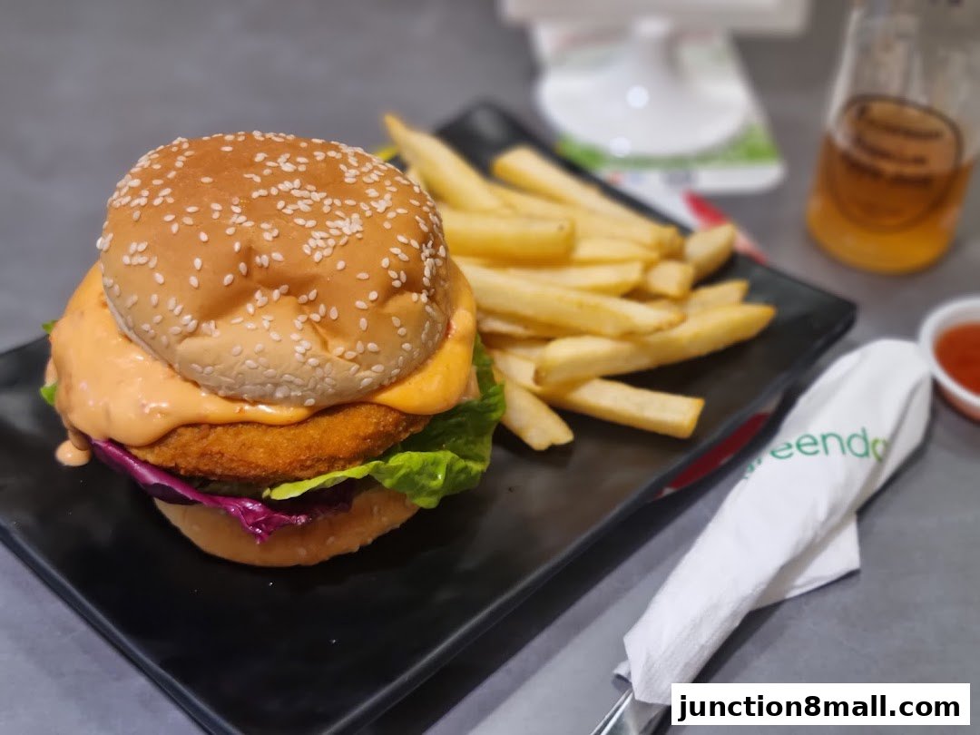 A delicious burger and fries served on a black plate with a napkin.