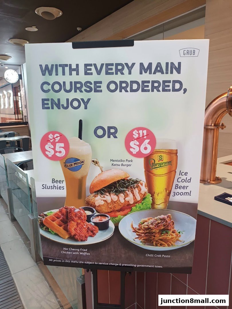 A promotional sign for GRUB Junction 8 offering deals on beer slushes, burgers, and pasta with main course orders.