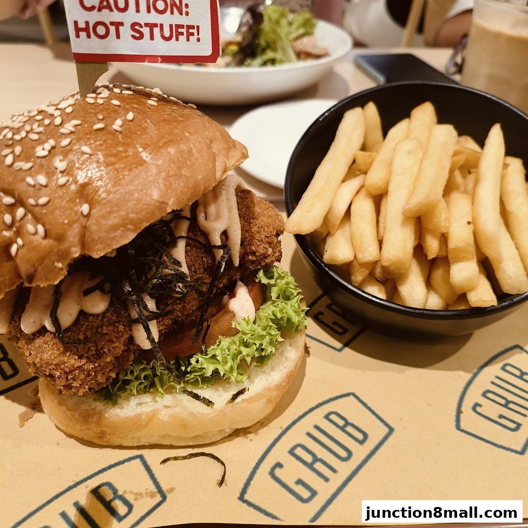 A delicious burger with fries and a salad in the background at GRUB Junction 8.