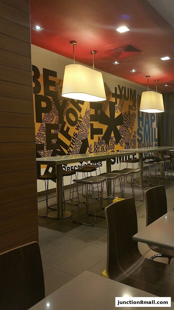 Interior shot of a dining area with tables, chairs, and a motivational wall.