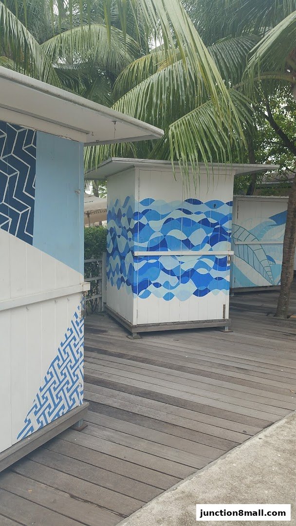 Two white kiosks with blue wave and geometric patterns, set on a wooden deck.