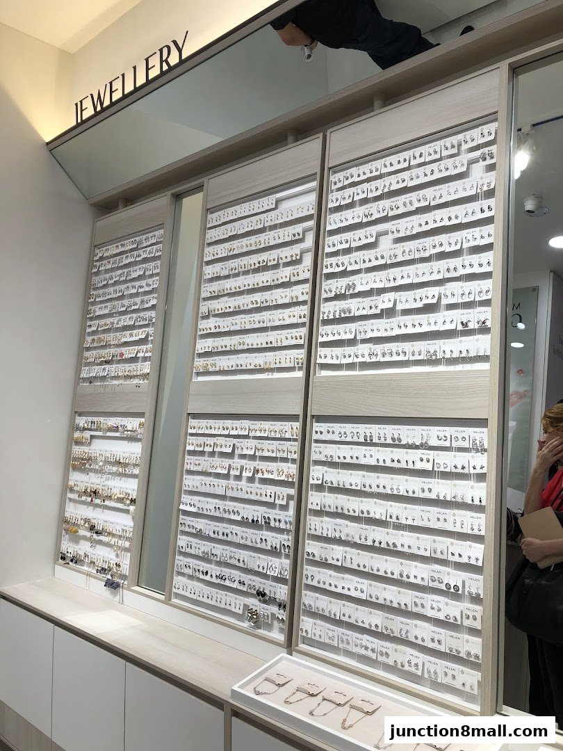 A well-lit jewelry store display featuring a vast collection of earrings and necklaces.