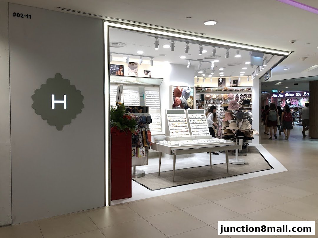 The entrance of a stylish accessories shop displaying jewelry, hats, and bags.