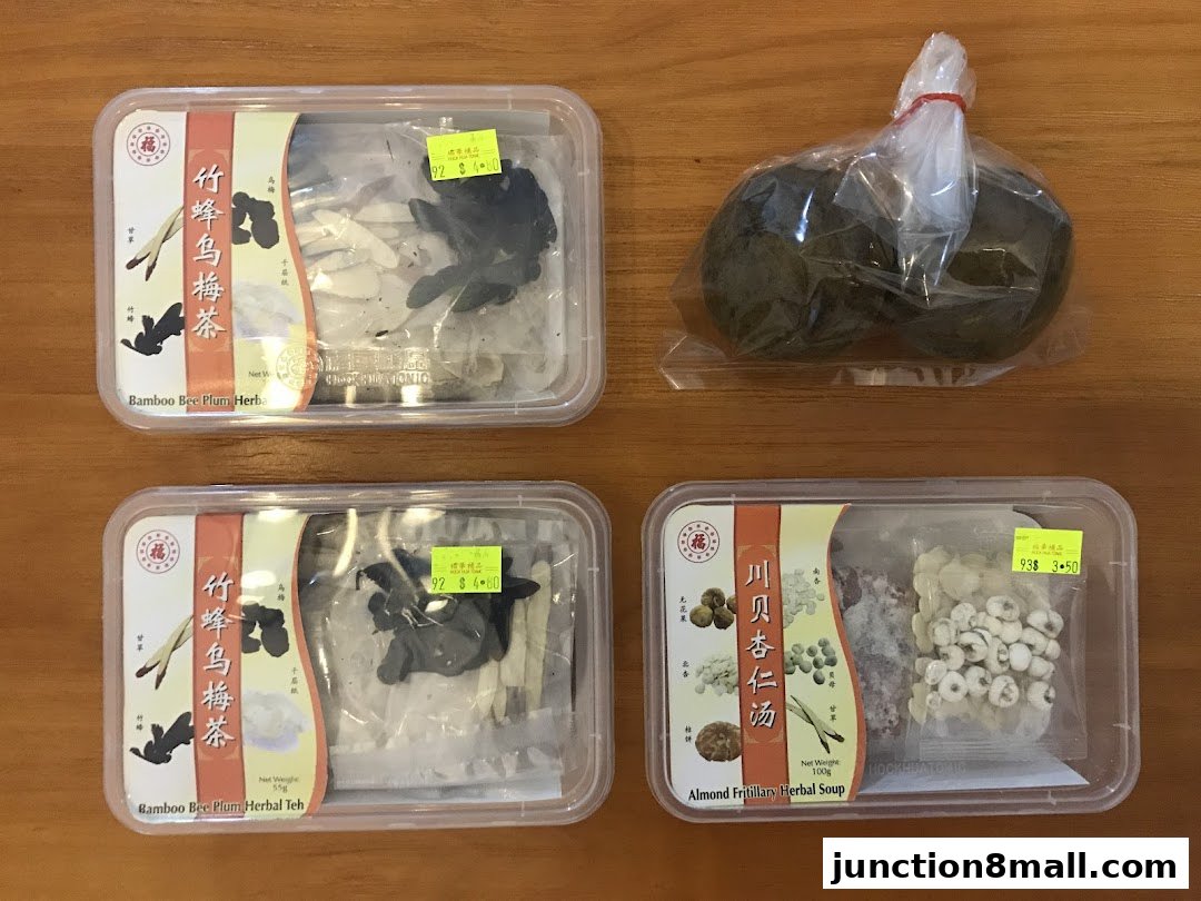Four packages of traditional Chinese herbal remedies and teas on a wooden surface.