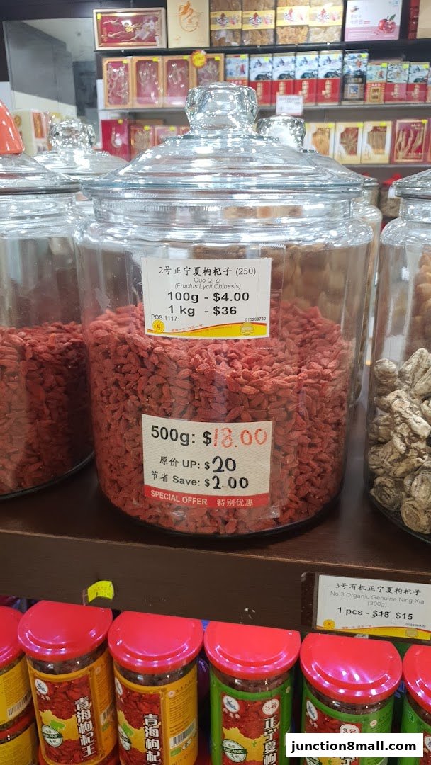 Large glass jars filled with dried goji berries, with price labels and other products in the background.