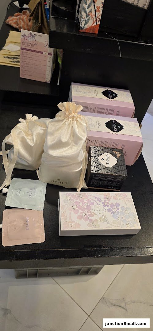 A display of various HYSSES specialty oil products, including boxed sets and small pouches.
