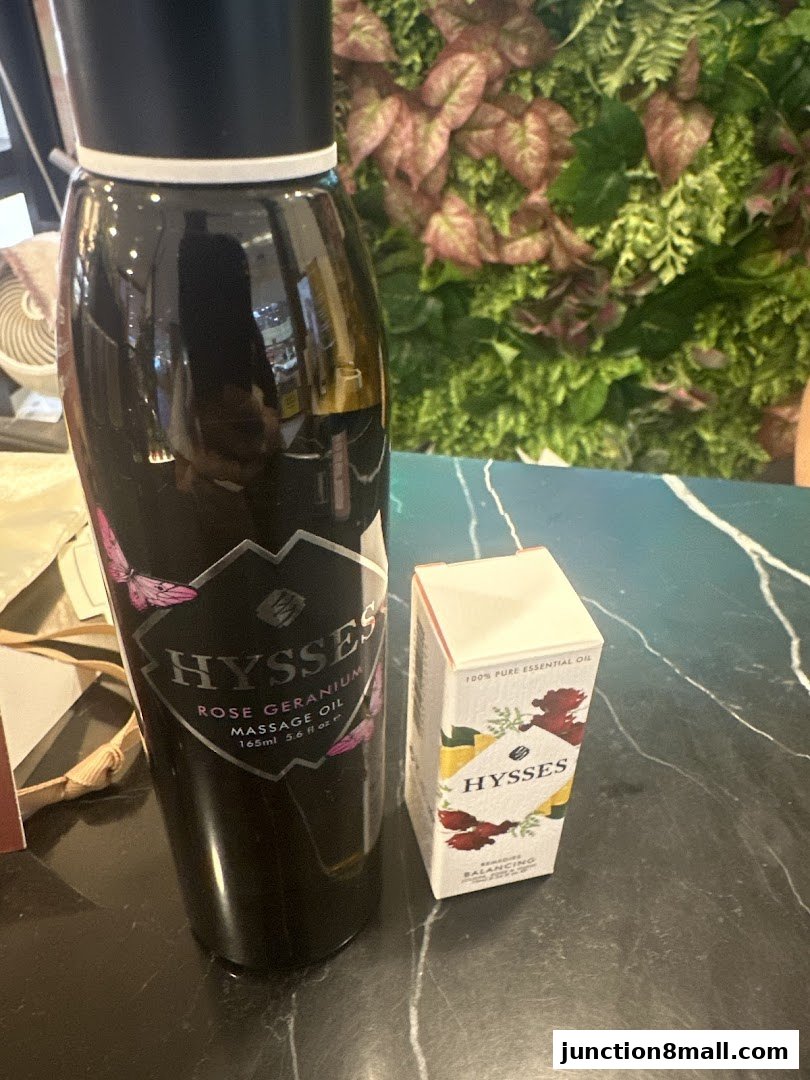 A large bottle of Rose Geranium massage oil and a small box of essential oil from HYSSES.
