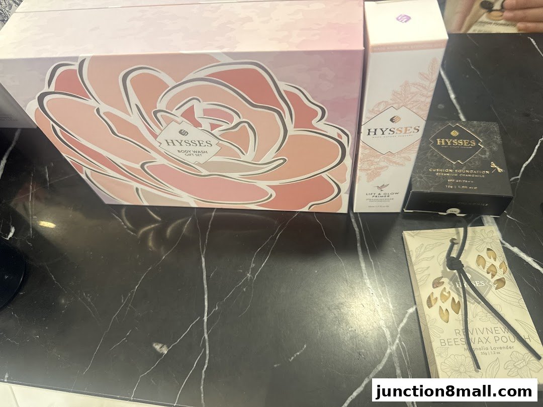 A collection of HYSSES beauty products including a gift set, primer, cushion foundation, and beeswax pouch.