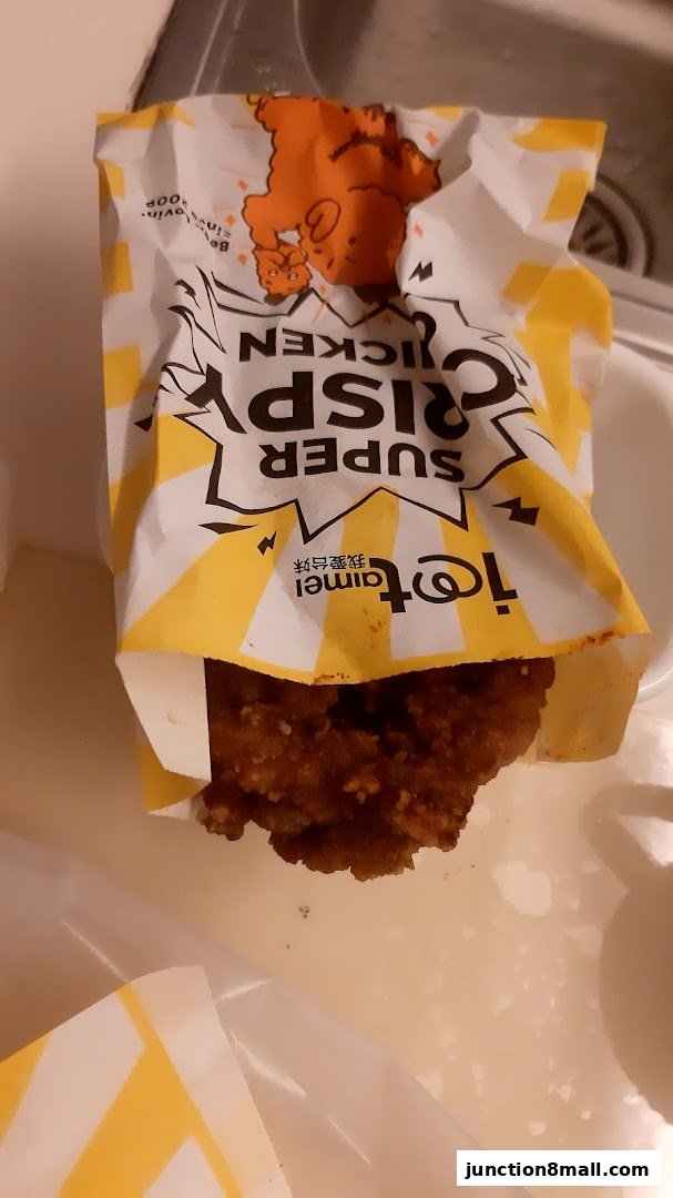 A piece of crispy fried chicken in a branded paper bag with cartoon characters.