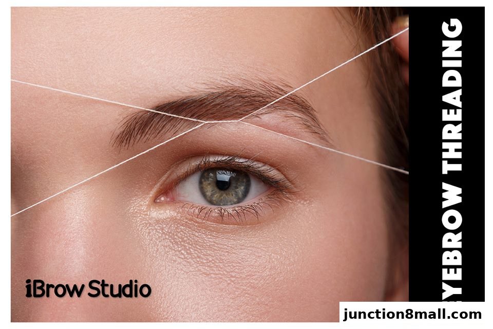 Close-up of a woman's eye with eyebrows being threaded.