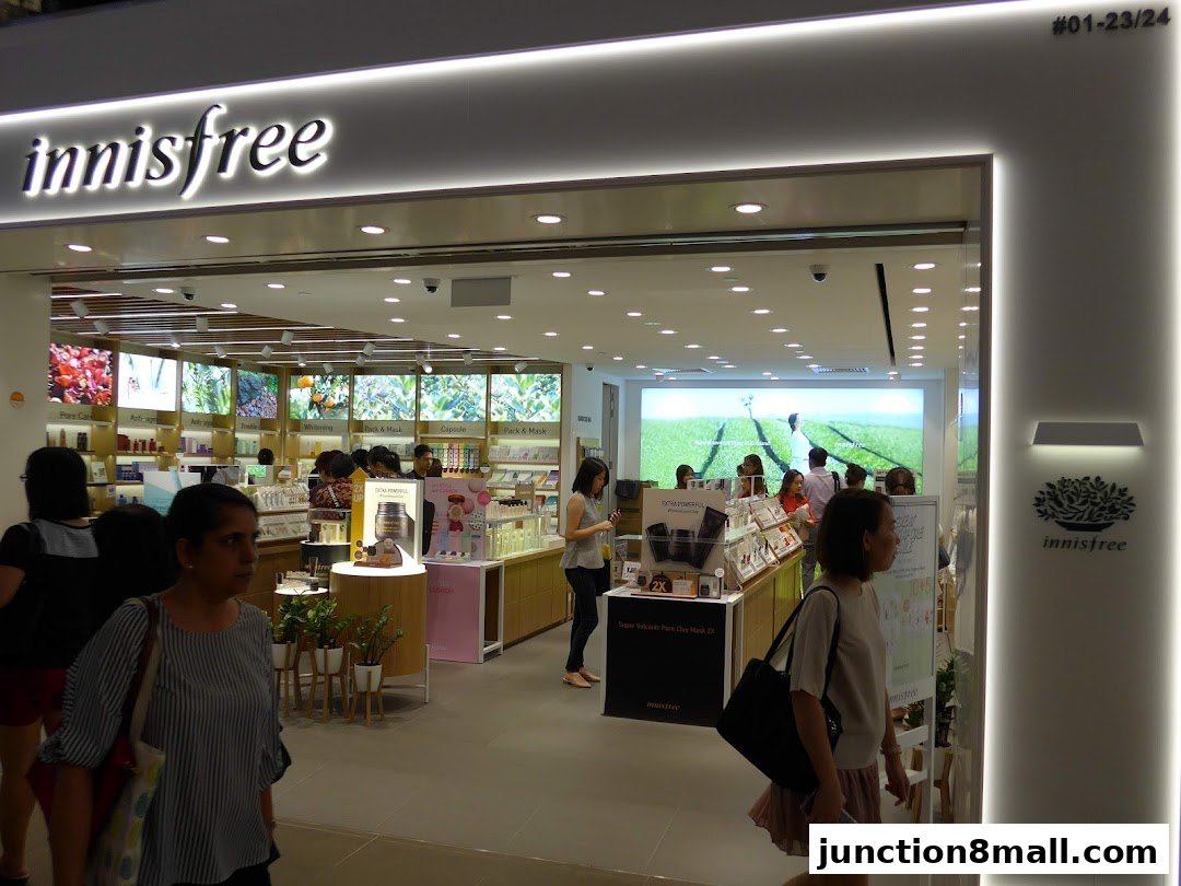 Innisfree store interior with customers browsing skincare products and displays.