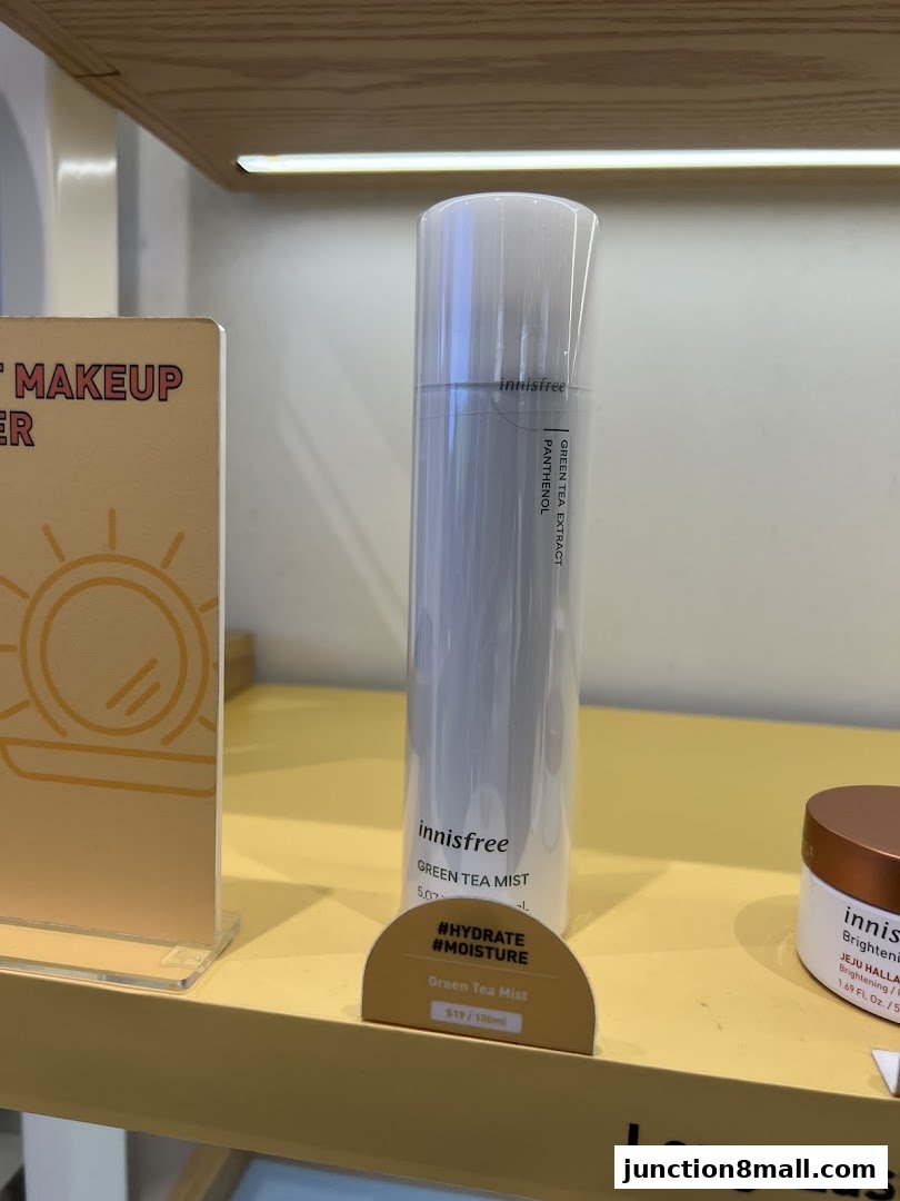 Innisfree Green Tea Mist product displayed on a shelf with marketing signage.