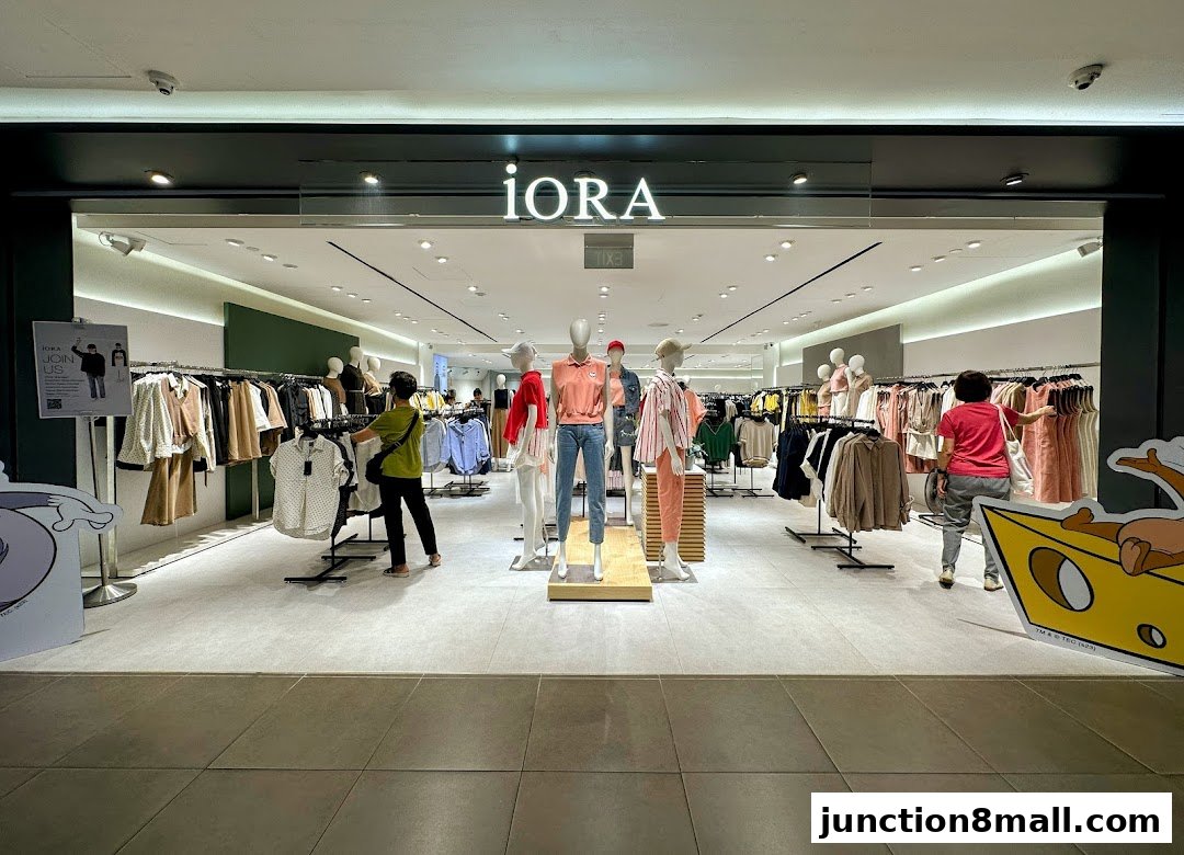 The iORA store features a well-lit interior with mannequins displaying fashionable clothing and racks of apparel.