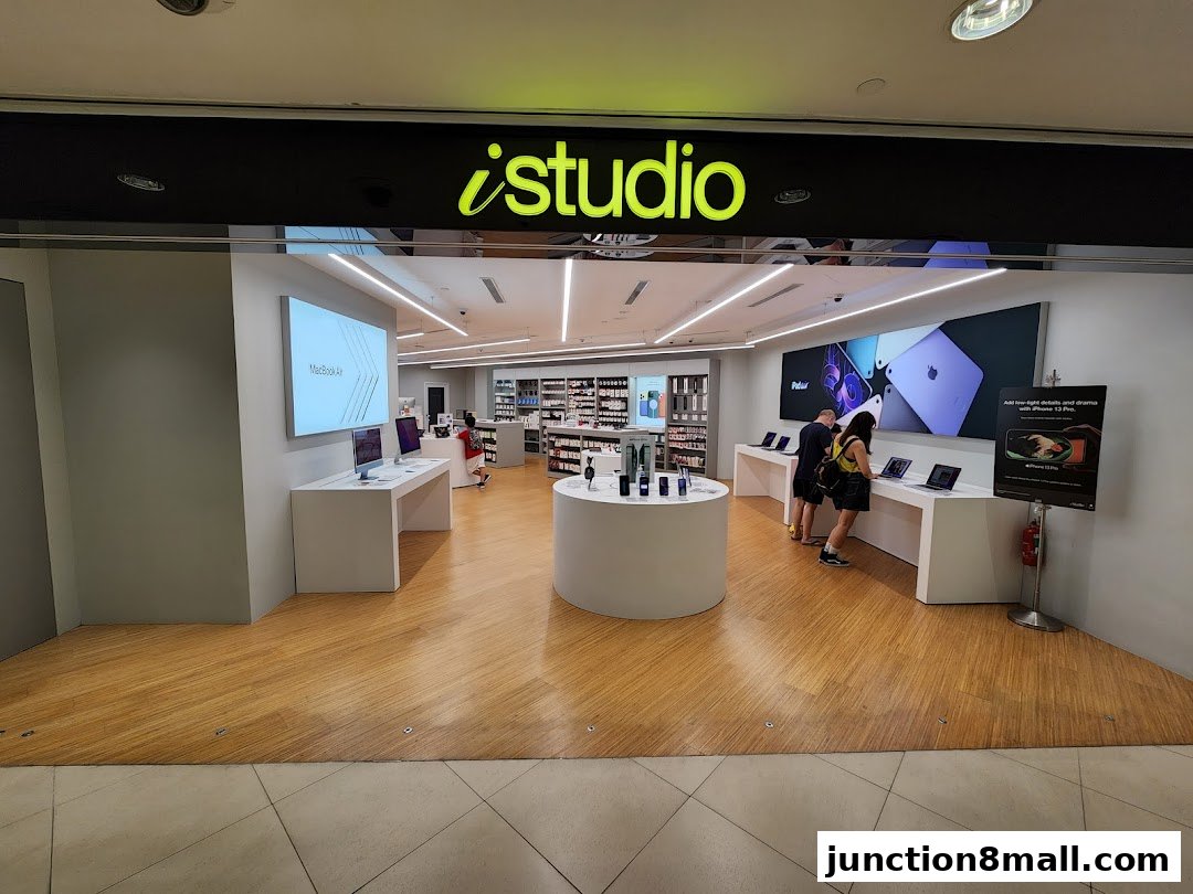 The entrance of an iStudio electronics store showcasing Apple products and displays.
