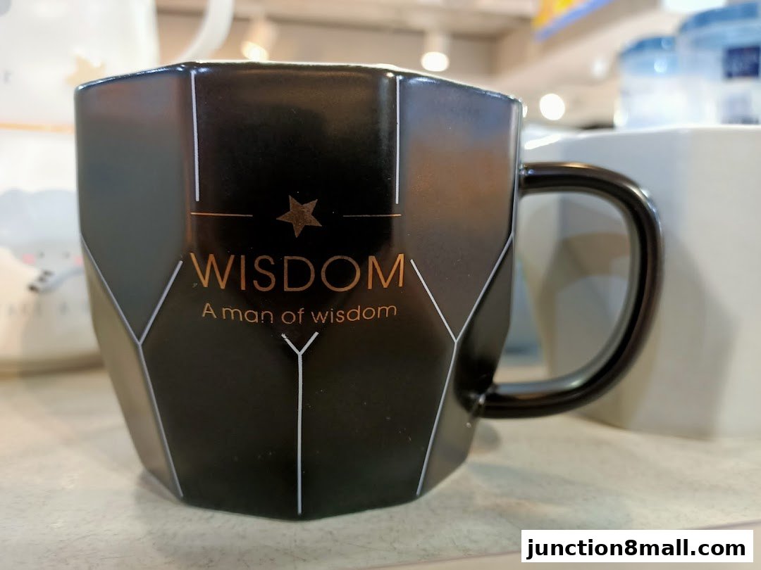 A black mug with the word 'WISDOM' and a star design is displayed.