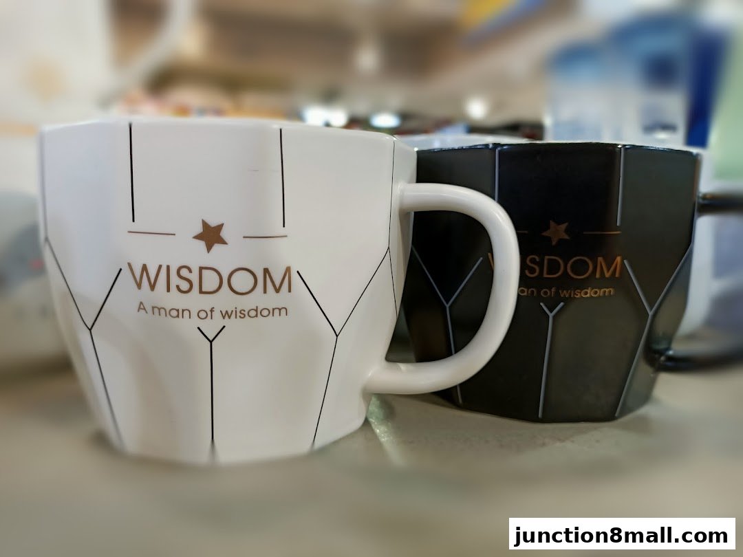 Two stylish mugs, one white and one black, with geometric patterns and the word 'WISDOM' printed on them.