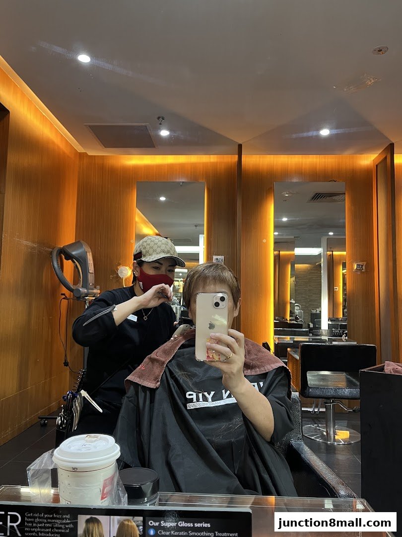 A person is getting their hair styled by a hairdresser in a salon.