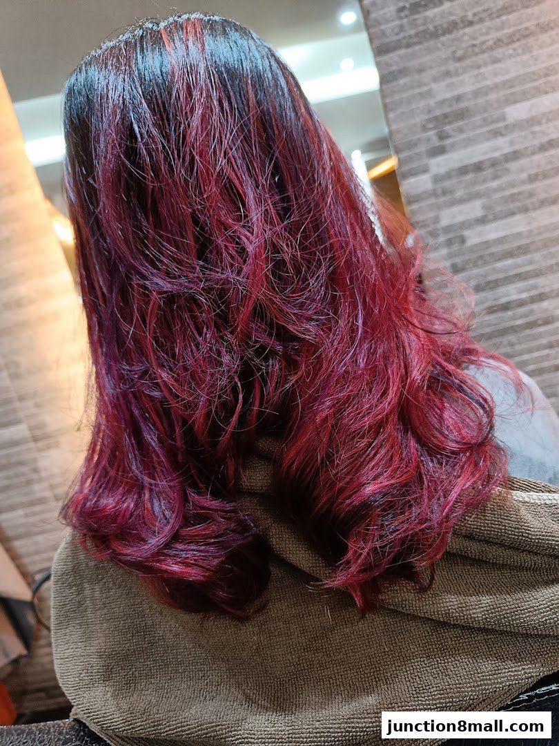 A person's back with freshly dyed, vibrant red and dark hair, styled with waves.