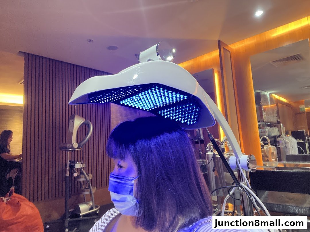 A woman receives a blue light therapy treatment for her hair in a salon.