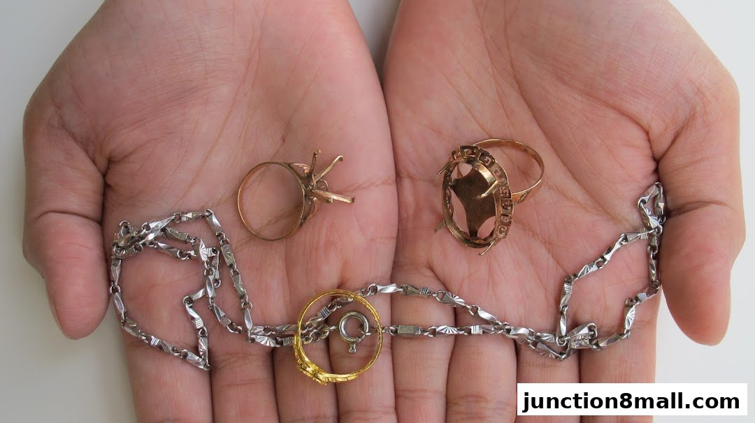 Hands holding gold rings and a silver chain, showcasing jewelry items.