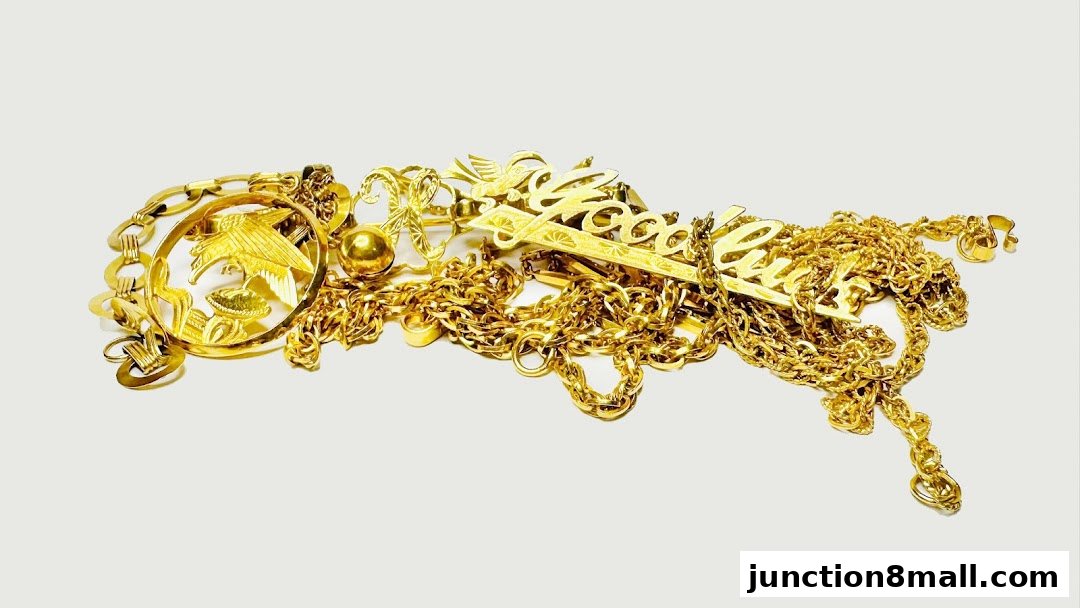 A pile of assorted gold necklaces and pendants, including a bird and floral motif.