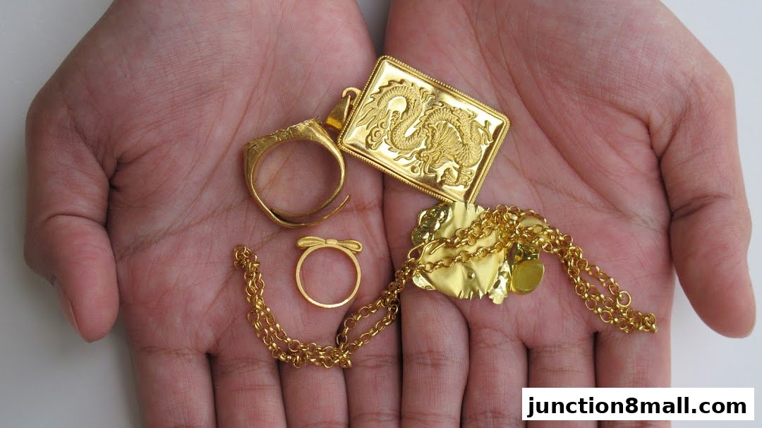Hands holding various gold jewelry items, including rings, a pendant, and a chain.