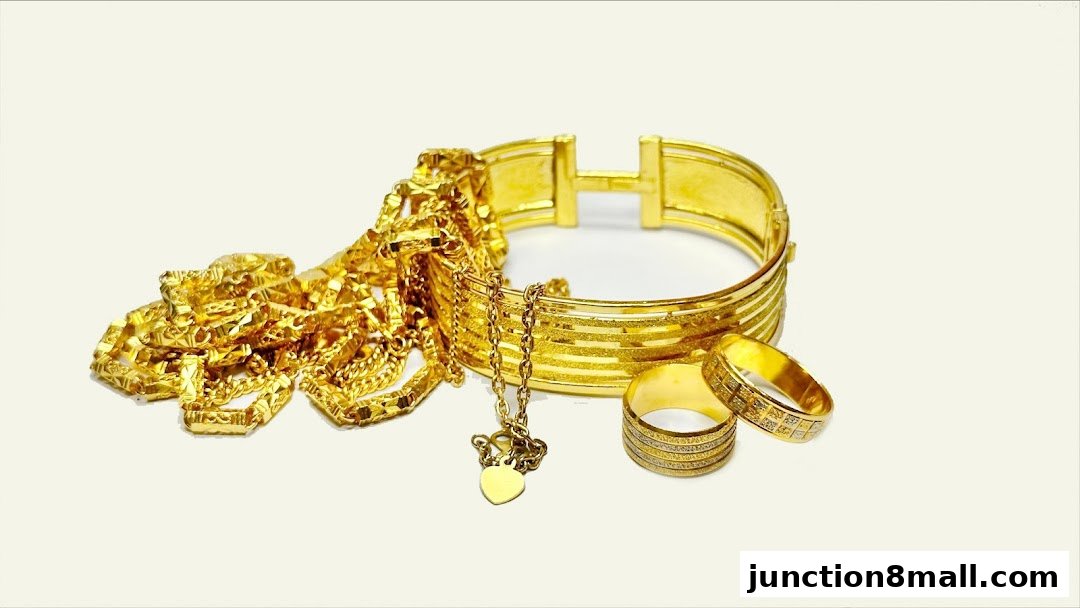 A collection of gleaming gold jewelry, including necklaces, bracelets, and rings, displayed against a plain background.