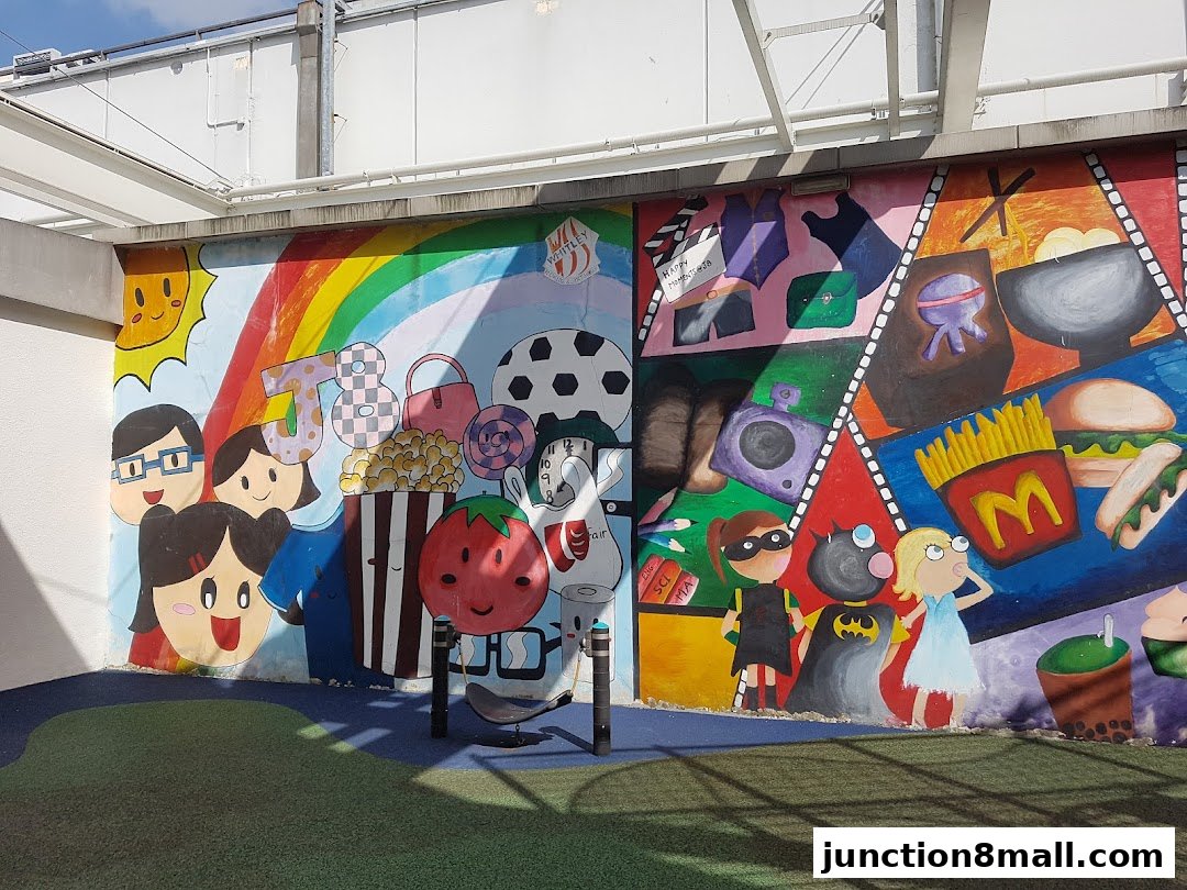 A colorful mural depicting various pop culture elements, food, and characters on a wall.