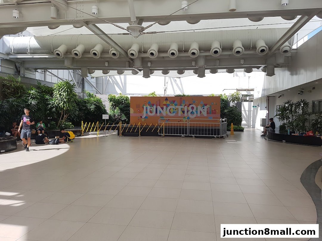 A wide view of an indoor plaza with a stage set up for an event.