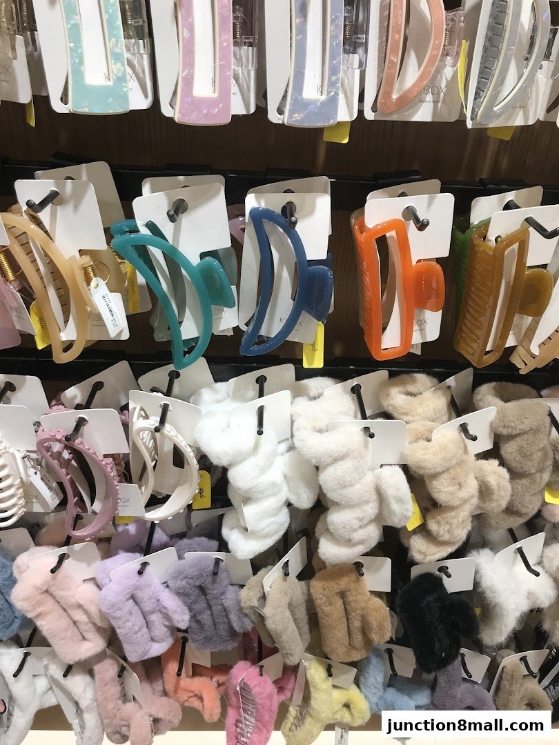 A display of colorful hair clips and scrunchies in various styles and textures.