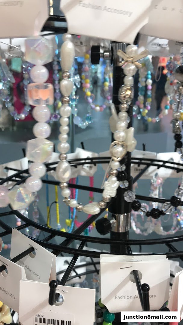 A display rack showcasing various beaded fashion accessories, including necklaces and bracelets.