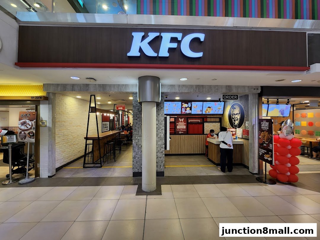 The exterior of a KFC restaurant with its iconic logo and ordering counter visible.