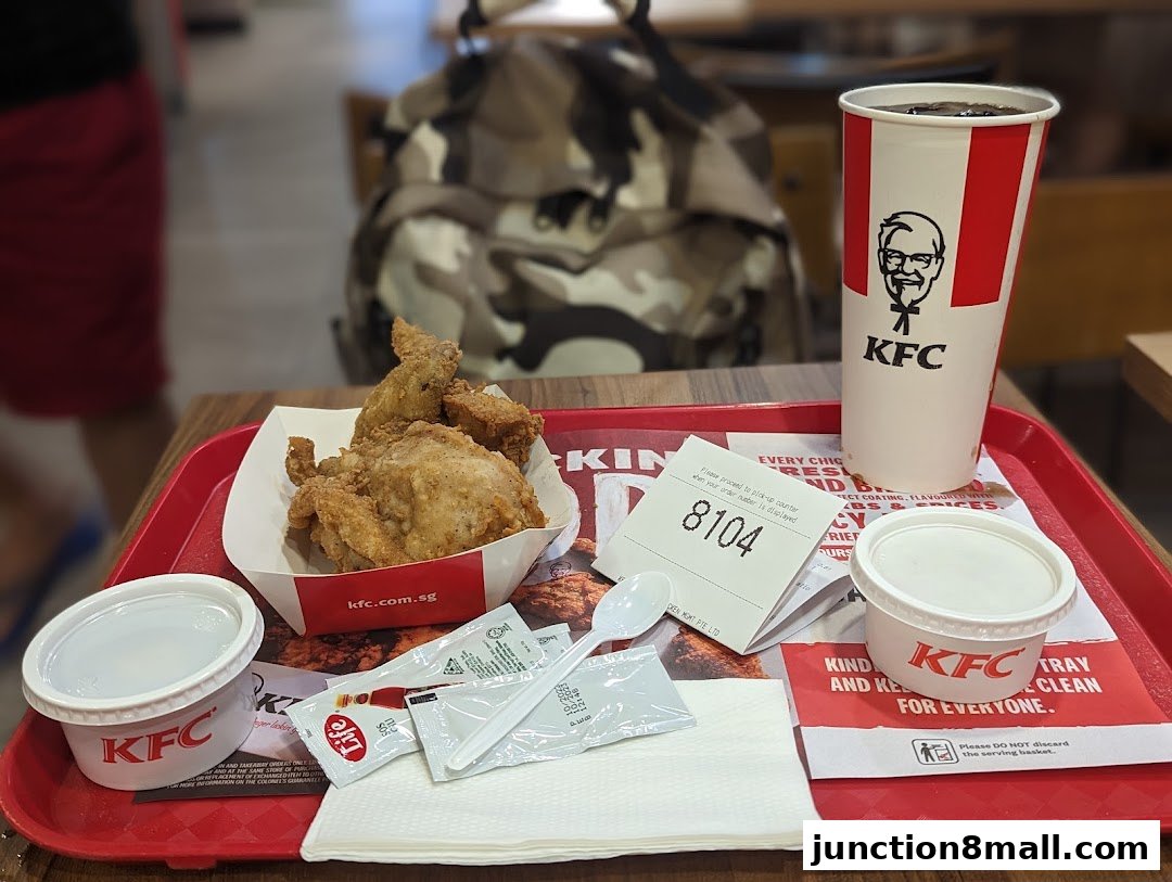 A tray of KFC fried chicken, a drink, and sides on a red tray.