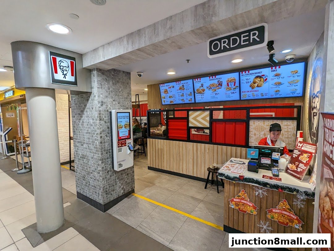 Interior view of a KFC restaurant with a counter, menu boards, and an employee.