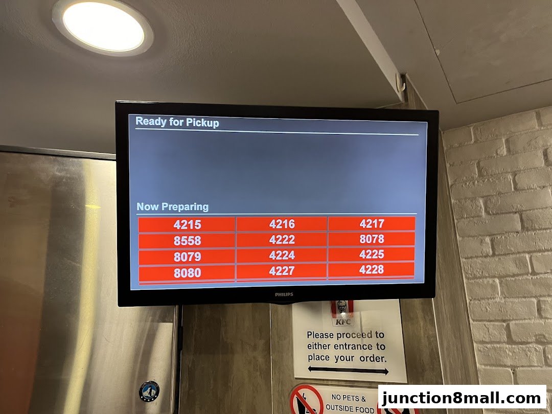 A screen displays order numbers ready for pickup and currently being prepared at KFC.