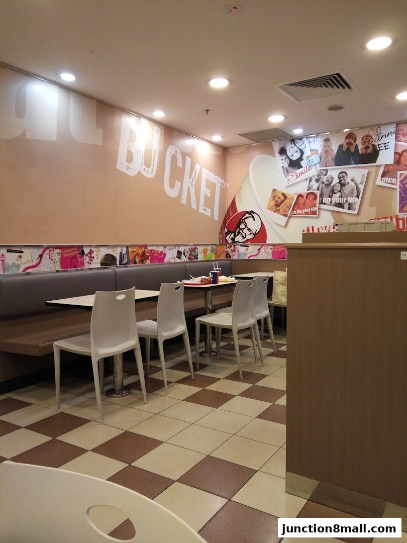 Interior of a KFC restaurant with seating, tables, and branded wall decor.