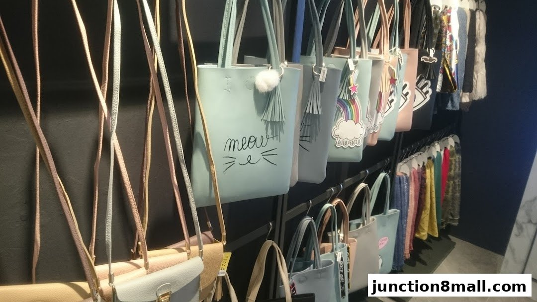 A display of various tote bags and scarves in different colors and designs.