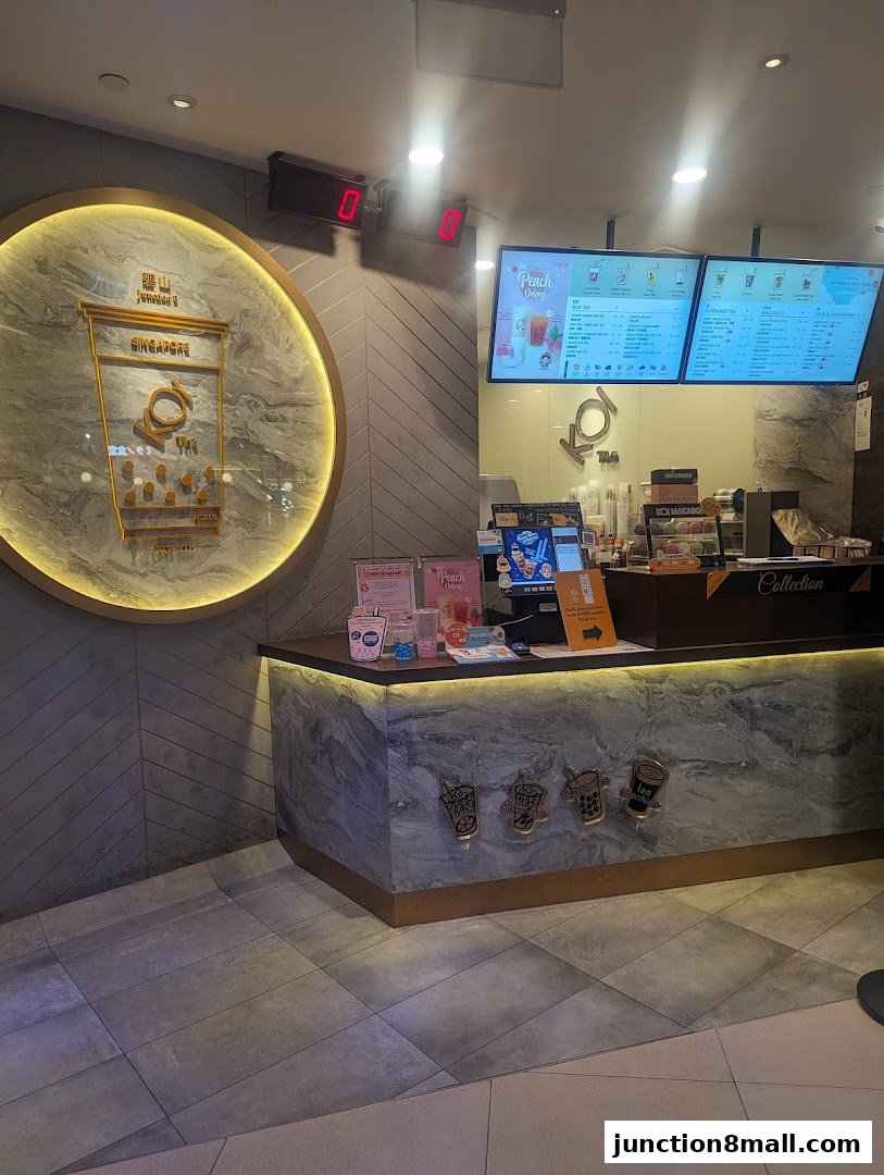 The interior of a KOI Thé bubble tea shop with a counter and digital menus.