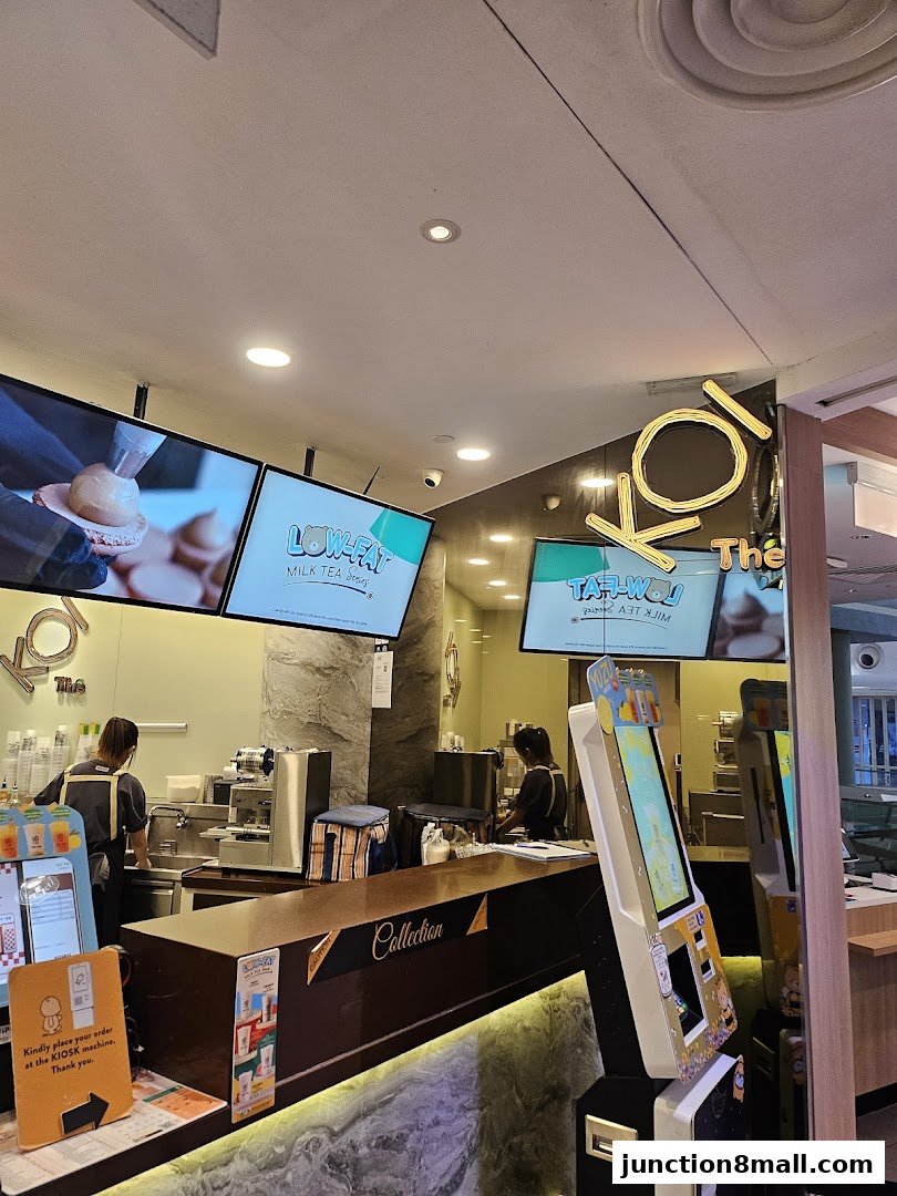 Interior view of a KOI Thé milk tea shop with staff and ordering kiosks.