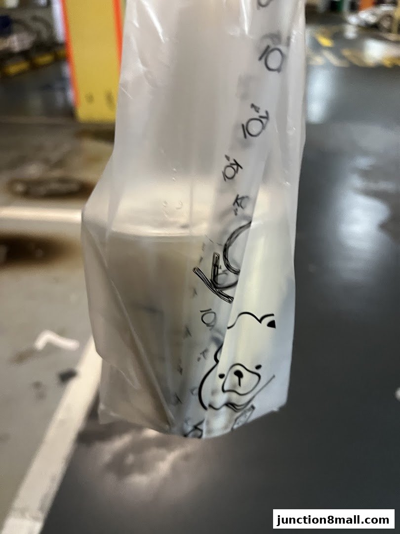 A plastic bag with a drink and a straw from KOI Thé.