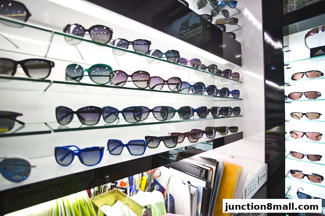 A display of various sunglasses and eyewear on shelves in a retail store.