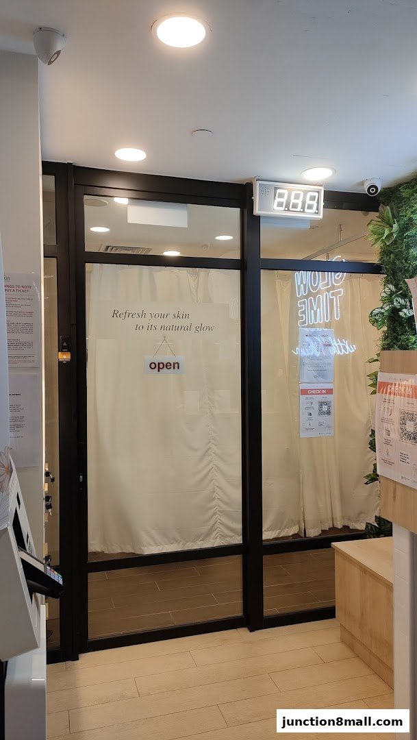 The entrance to Kskin Korean Express Facial, featuring a glass door with an 'open' sign and promotional text.