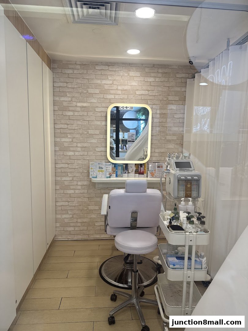 A clean and modern facial treatment room with a chair, mirror, and equipment.