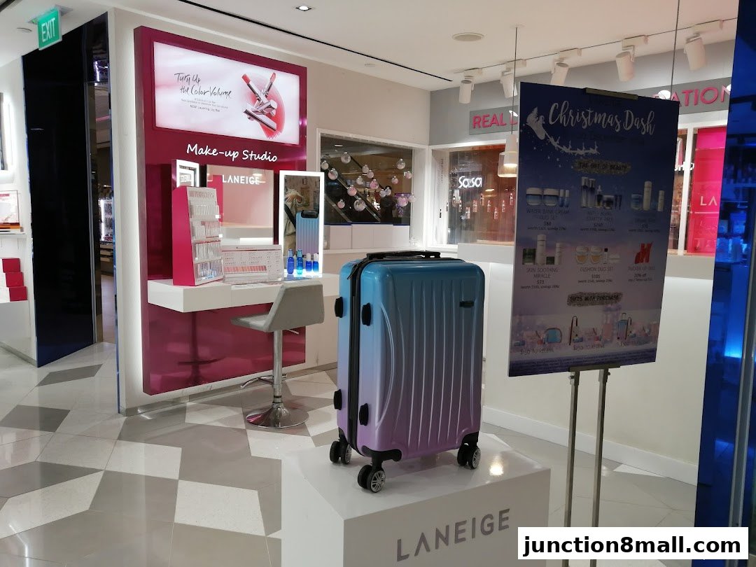A LANEIGE makeup studio with a display, chair, and a gradient suitcase.
