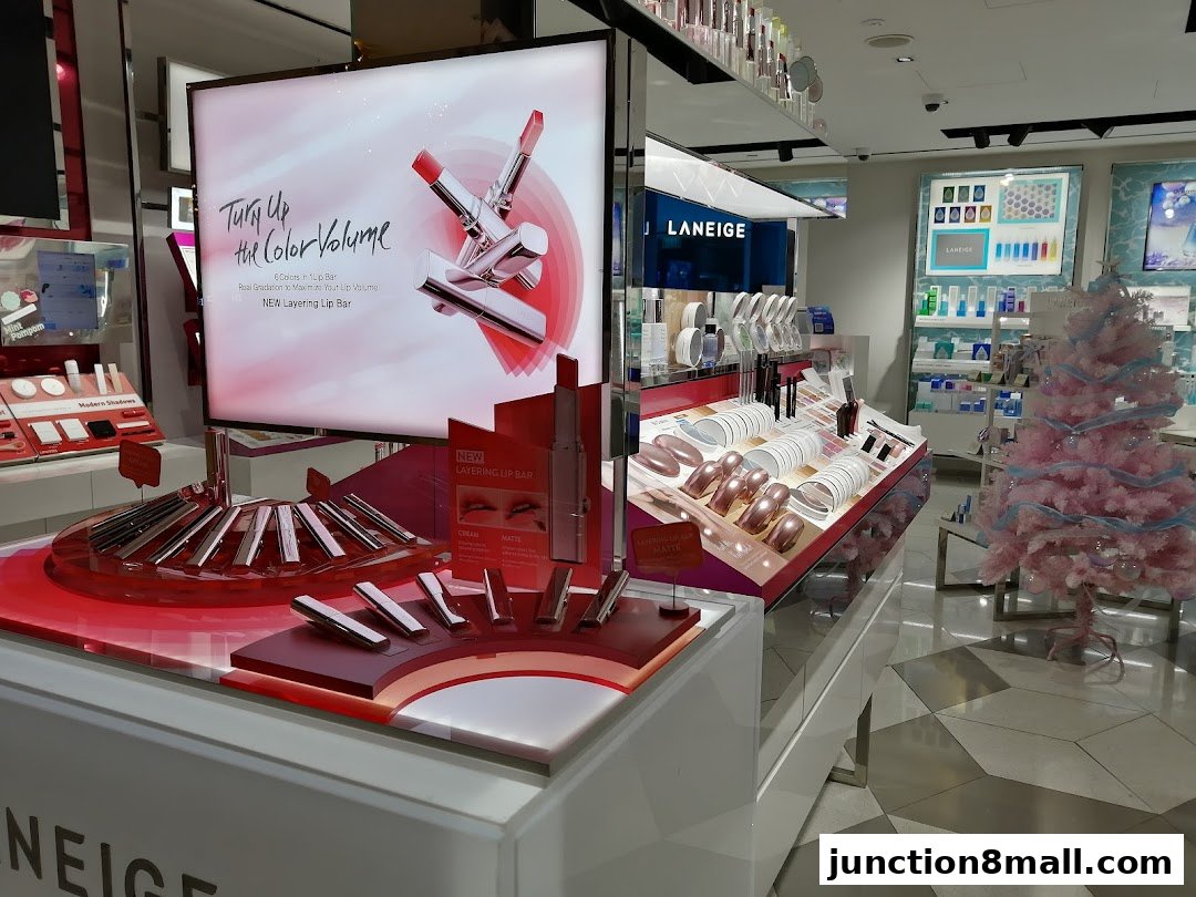 A LANEIGE beauty store display featuring lipsticks, makeup, and a festive pink Christmas tree.