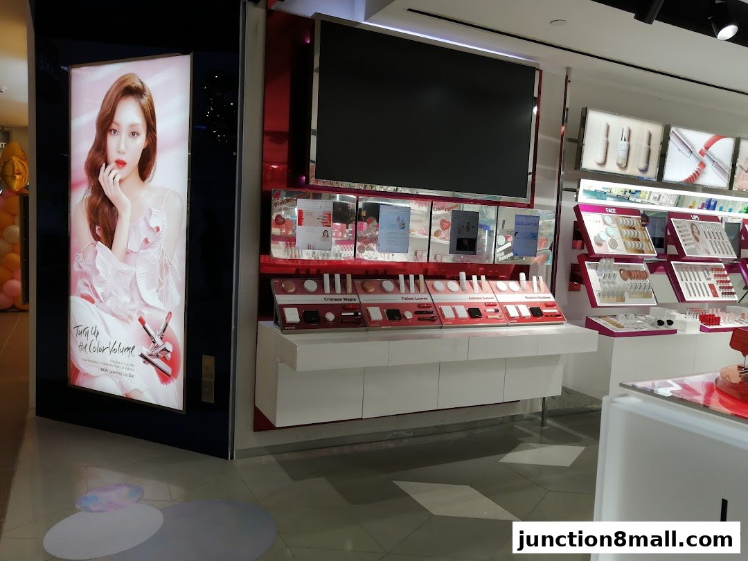 A beauty store display featuring makeup products and a large advertisement with a model.