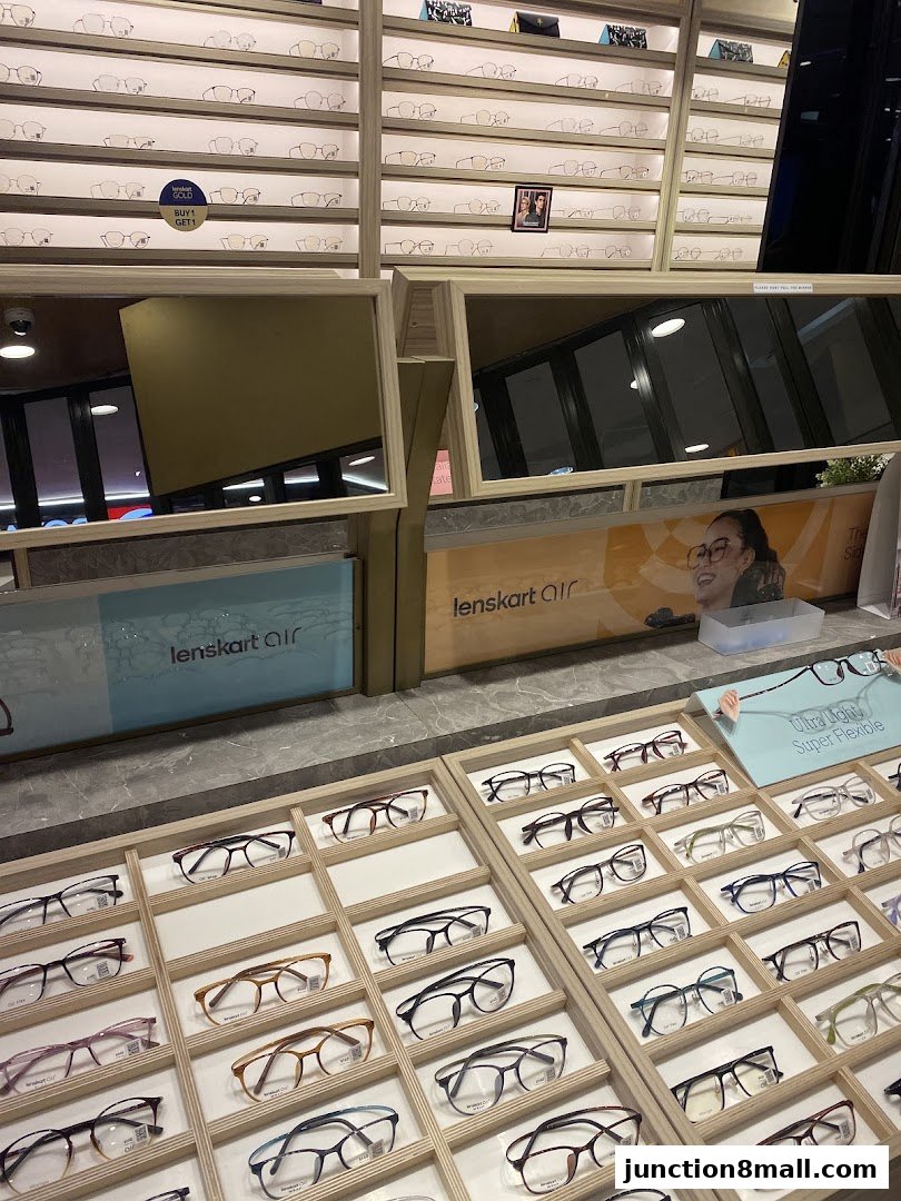 A display of various eyeglasses in wooden frames at Lenskart Junction 8.