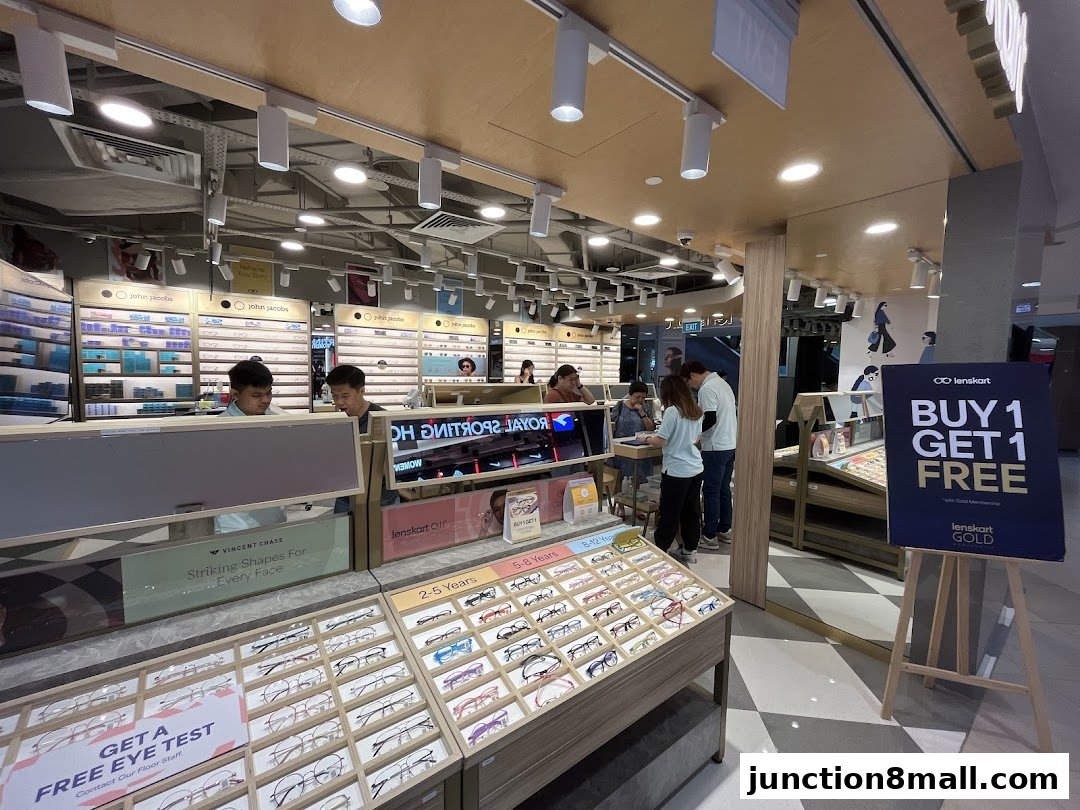 Interior of Lenskart store with displays of eyeglasses and customers being assisted.
