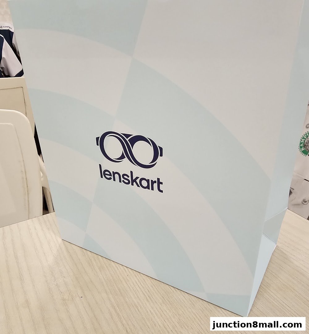 A shopping bag with the Lenskart logo and a checkered pattern.
